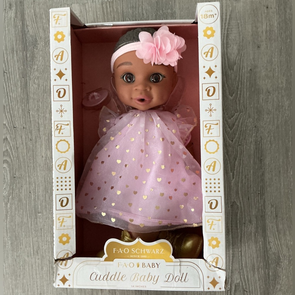 FAO Schwarz 14-inch Cuddle Baby Doll with dark brown hair and brown eyes